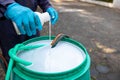 exterminate termite control company employee is using termite sprayer at customer's house and searching for termite nests to