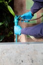 exterminate termite control company employee is using a termite sprayer at customer house and searching for termite nests to