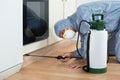 Exterminator Spraying Pesticide On Wooden Cabinet Royalty Free Stock Photo