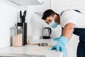 Exterminator standing near kitchen cabinet and Royalty Free Stock Photo