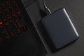 An external hard drive connected to the laptop with a usb cable on a black background. Royalty Free Stock Photo