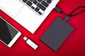 External hard drive connected to the laptop, USB flash drive and smartphone on a red background Royalty Free Stock Photo