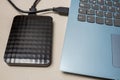 External hard drive with usb cable connected to a laptop or notebook computer on a rustic surface Royalty Free Stock Photo