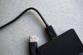 External hard drive with usb cable on a gray background Royalty Free Stock Photo