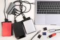 External hard drives connected to a laptop on white desk Royalty Free Stock Photo