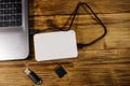 External HDD connected to laptop computer, SD memory card and USB flash drive on wooden desk. Top view. Concept of data storage Royalty Free Stock Photo