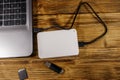 External HDD connected to laptop computer, SD memory card and USB flash drive on a wooden desk. Top view Royalty Free Stock Photo