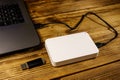 External HDD connected to laptop computer and USB flash drive on a wooden desk. Concept of data storage Royalty Free Stock Photo