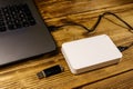 External HDD connected to laptop computer and USB flash drive on a wooden desk. Concept of data storage Royalty Free Stock Photo