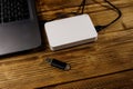 External HDD connected to laptop computer and USB flash drive on a wooden desk. Concept of data storage Royalty Free Stock Photo