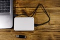 External HDD connected to laptop computer and USB flash drive on wooden desk. Top view. Concept of data storage Royalty Free Stock Photo