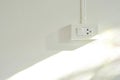 External light switch and sockets on white concrete wall background with sunshine reflection
