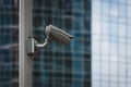 External security camera on pole in front of glass building wall Royalty Free Stock Photo