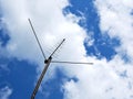 External television antenna on a background of blue sky and clouds. Shot in the summer in the countryside. Vivid illustration on