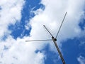 External television antenna on a background of blue sky and clouds. Shot in the summer in the countryside. Vivid illustration on