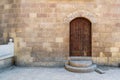 External vaulted closed decorated wooden grunge door in bricks stone wall Royalty Free Stock Photo