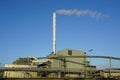 External view of large modern biomass cogeneration wood chip power plant with tall steam chimney