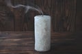 Extinguished big candle in the dark. On a wooden background. Candle smoke Royalty Free Stock Photo