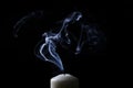 Extinguished candle with blue smoke