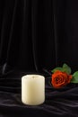 An extinguished candle and a red rose on a black background. The concept of mourning, condolences, funerals Royalty Free Stock Photo