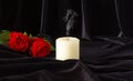 An extinguished candle and a red rose on a black background. The concept of mourning, condolences, funerals Royalty Free Stock Photo