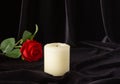 An extinguished candle and a red rose on a black background. The concept of mourning, condolences, funerals Royalty Free Stock Photo