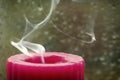 Extinguished candle and smoke curves on a blurred background. A symbol of sorrow and memory of dead people Royalty Free Stock Photo