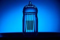 Extinguished electric vintage Edison light bulb with a spiral on a blue background. Retro style lamp