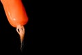 Extinguished orange candle with burned wick on black background Royalty Free Stock Photo