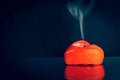 Extinguished red heart shaped candle with smoke from the wick on a black background Royalty Free Stock Photo
