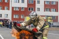 Extinguishing a major fire. A professional fireman in a special suit extinguishes an open fire with a fire extinguisher