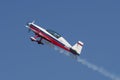 Extra aerobatic aircraft climbing with smoke