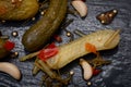 Extra Fine Cornichons - minuscule sour French pickles on natural stone background. Mini French style Gherkin Cucumbers