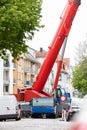 Extra heavy weight load mobile boom crane working on narrow european old city street background. Telescopic boom lifting