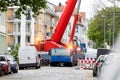 Extra heavy weight load mobile boom crane working on narrow european old city street background. Telescopic boom lifting