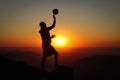 Extra-league volleyball player stands on a stump at the top of a mountain and plays with a volleyball ball in one hand at sunset. Royalty Free Stock Photo