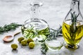 Oil in carafe with spices and olive on stone background