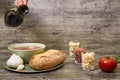 Extra virgin olive oil being served with Andalusian gazpacho in a bowl. Accompanied by bread and garlic, and on the right are