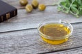 Extra virgin olive oil in a glass container with a closed Holy Bible Book, green olive branch, and olives on a wooden table Royalty Free Stock Photo