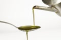 Extra virgin olive oil pouring over a spoon on white background Royalty Free Stock Photo