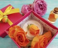 Extract, essence gift box cosmetic composition cream beautiful fresh orange rose on a blue wooden background