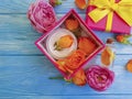 Extract, essence gift box cosmetic product bow composition cream beautiful fresh orange rose on a blue wooden background