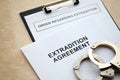 Extradition Agreement and Order Regarding Extradition with handcuffs on table Royalty Free Stock Photo