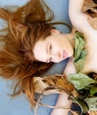 Extraordinary portrait with dry plant parts of a beautiful seductive young sexy woman with red brown hair artfully decorated