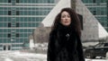 extravagant female city dweller on street at winter, long curly hair and tattoos brows