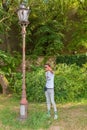 Extravagant hipster male model in nature. The guy poses in front of an old street light.
