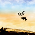 Extrem Sport. Silhouette of young man doing jump with bmx bike on the background of bright sky. Risky moment of falling Royalty Free Stock Photo