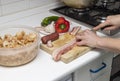 Extremadura crumbs, traditional dish. Hands cutting bacon, ingredients breadcrumbs, bacon, red and green pepper, crumbs, chorizo,