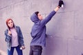 Extremal dark-haired guy using bottle of spray paints