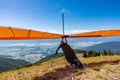 Extremal man with hang-glider preparing to fly